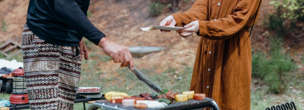 キャンプ場でバーベキューをしてお皿に取り分けている様子