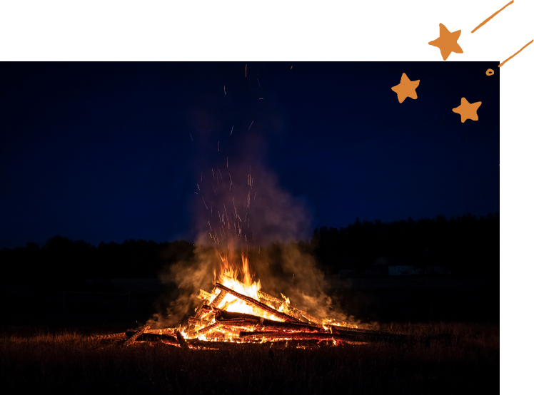 夜のキャンプ場で焚き火をしている様子