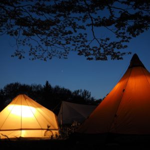 夕暮れ時にライトアップされたキャンプ場のテント